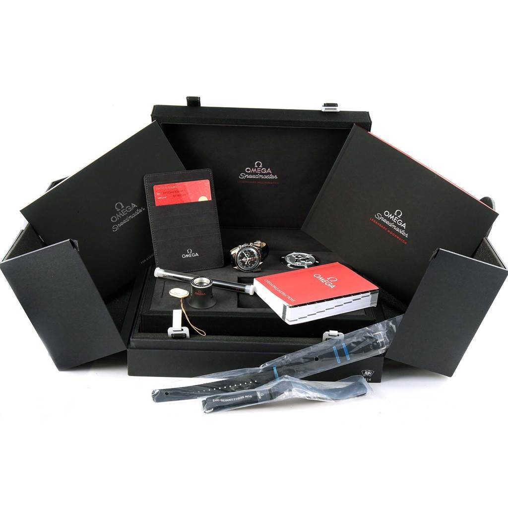 The image shows the Omega Speedmaster 311.30.42.30.01.005 Men
s Stainless Steel Black Dial 311.30.42.30.01.005 Men
s Stainless Steel Black Dial watch and its accessories from a top angle, including manuals, a loupe, straps, and a cardholder.