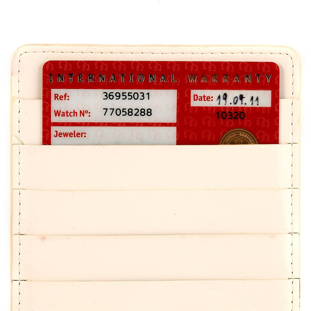 The image shows an Omega Speedmaster 3695.50.31 Men's Yellow Gold Black Dial 3695.50.31 Men's Yellow Gold Black Dial International Warranty card stored in a white cardholder.