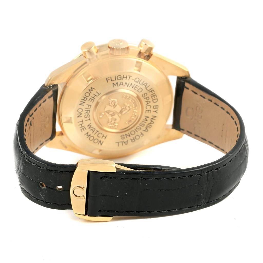 The image shows the backside of an Omega Speedmaster 3695.50.31 Men's Yellow Gold Black Dial 3695.50.31 Men's Yellow Gold Black Dial watch, highlighting the case back engraving and leather strap.