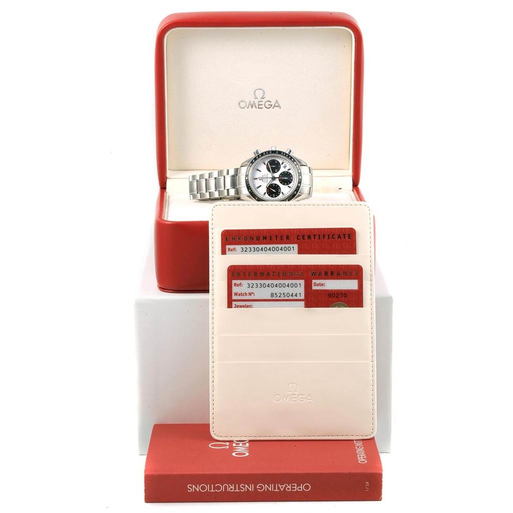 The Omega Speedmaster 323.30.40.40.04.001 Men's Stainless Steel White Dial 323.30.40.40.04.001 Men's Stainless Steel White Dial watch is shown in its open box, along with warranty cards and an operating instructions booklet.