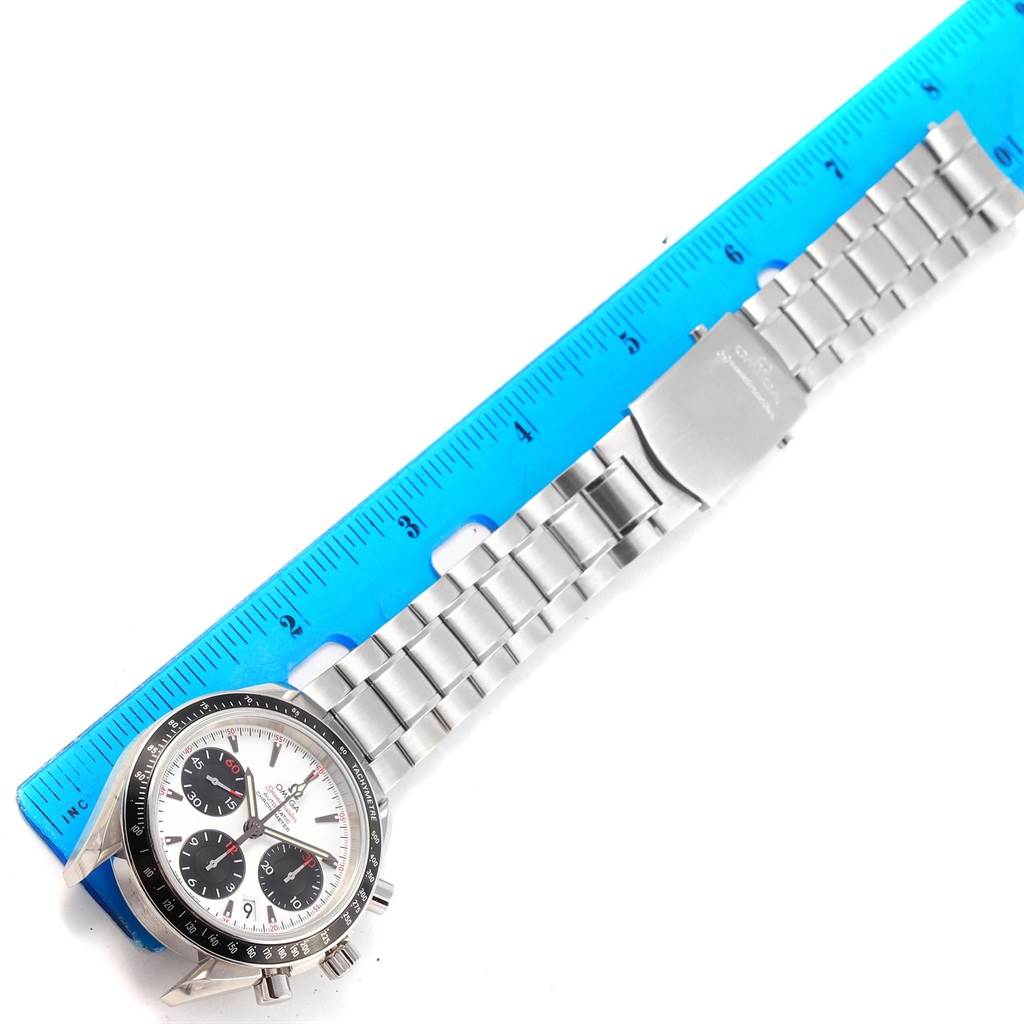 The image shows an Omega Speedmaster 323.30.40.40.04.001 Men's Stainless Steel White Dial 323.30.40.40.04.001 Men's Stainless Steel White Dial watch laid flat next to a blue ruler, displaying the face, bezel, and stainless steel bracelet.