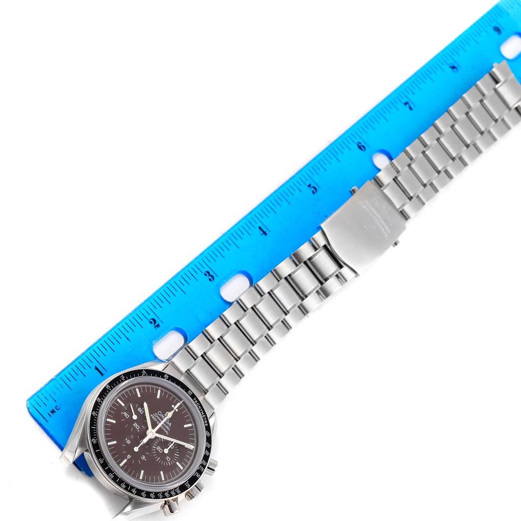 The image shows an Omega Speedmaster 311.30.42.30.13.001 Men's Stainless Steel Brown Dial 311.30.42.30.13.001 Men's Stainless Steel Brown Dial watch laid flat and measured with a blue ruler.