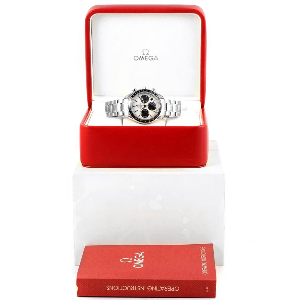 The image shows an Omega Speedmaster 323.30.40.40.02.001 Men's Stainless Steel White Dial 323.30.40.40.02.001 Men's Stainless Steel White Dial watch in an open red box with a user manual placed in front of it.