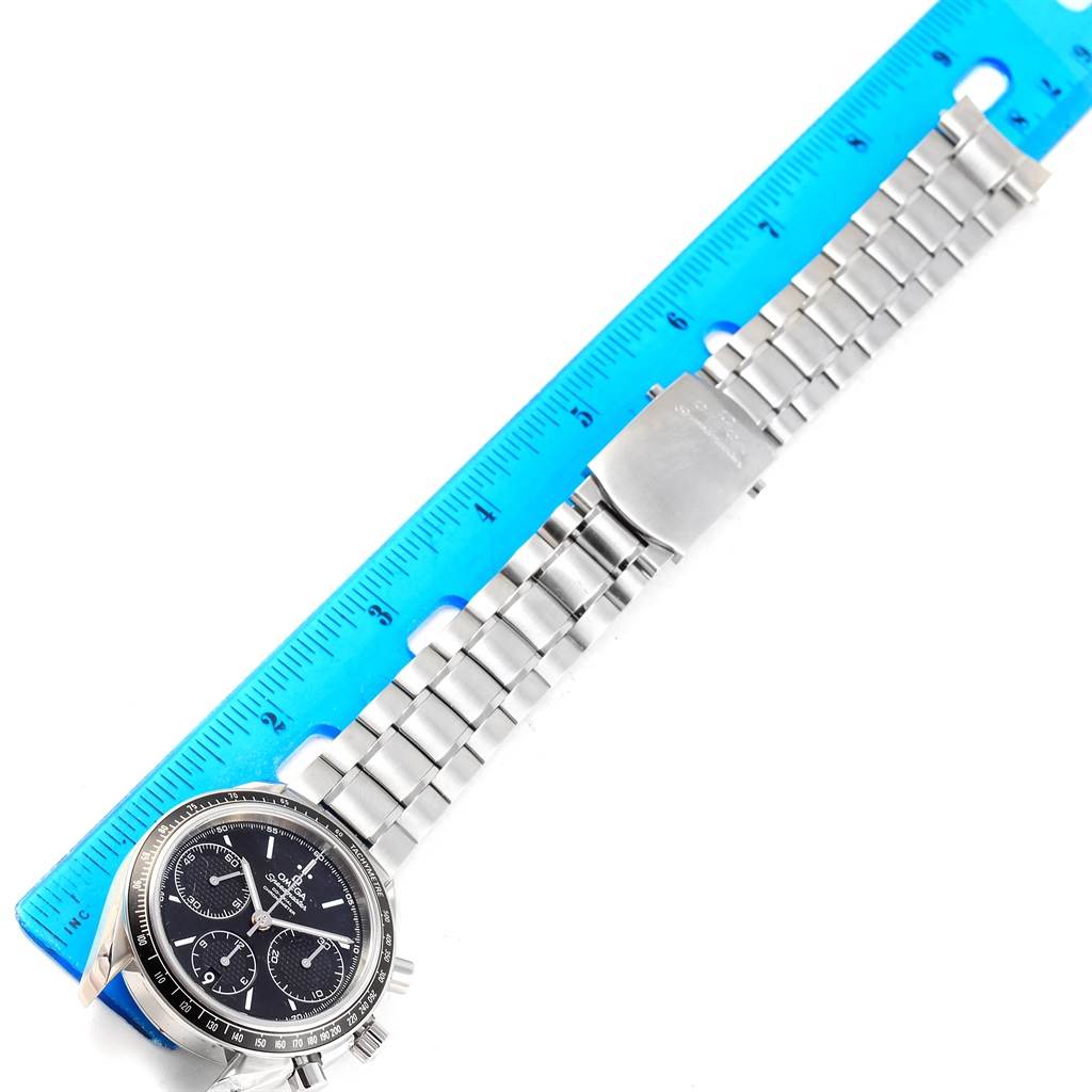 This image shows a side view of an Omega Speedmaster 326.30.40.50.01.001 Men
s Stainless Steel Black Dial 326.30.40.50.01.001 Men
s Stainless Steel Black Dial watch and its stainless steel bracelet placed next to a ruler.