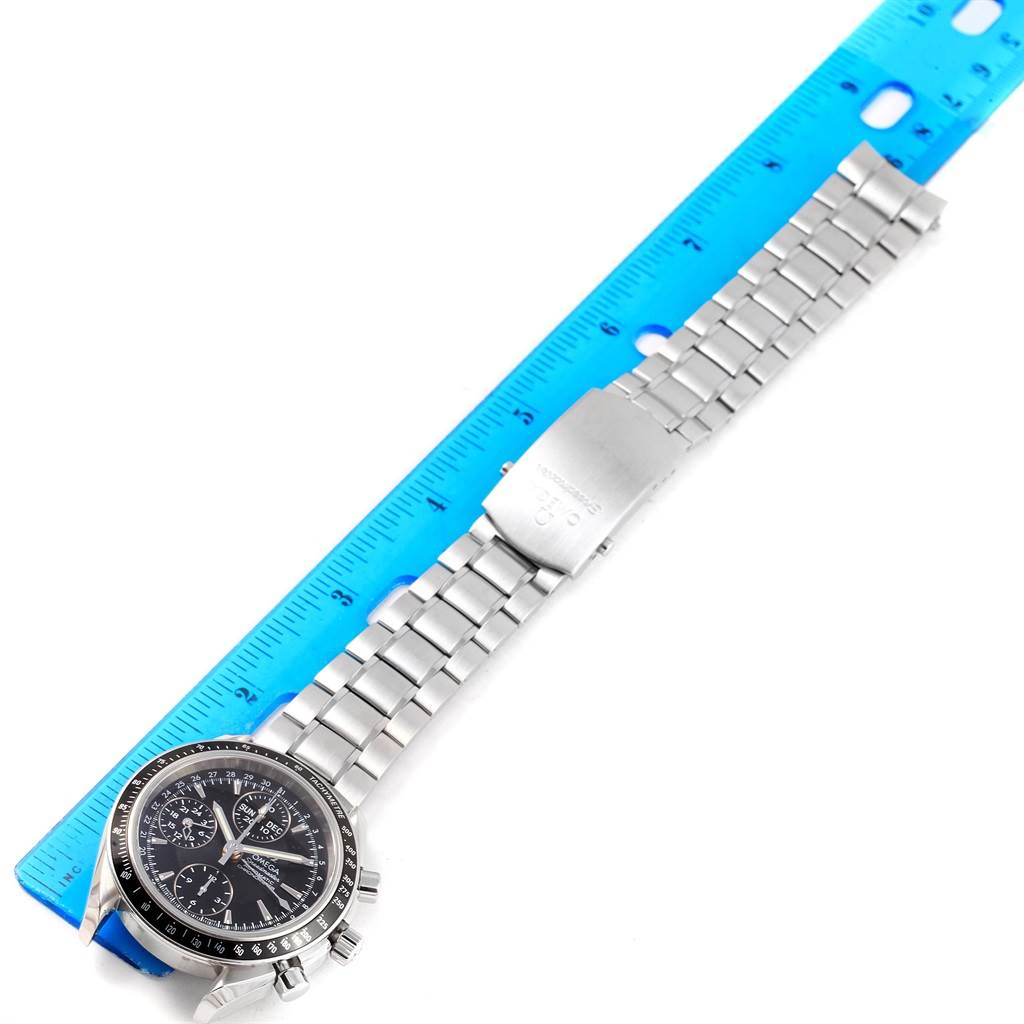 The image shows an Omega Speedmaster 3220.50.00 Men
s Stainless Steel Black Dial 3220.50.00 Men
s Stainless Steel Black Dial watch laid flat alongside a blue ruler, displaying the watch face and metal band.