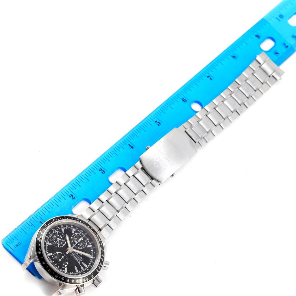 The image shows an Omega Speedmaster 3220.50.00 Men
s Stainless Steel Black Dial 3220.50.00 Men
s Stainless Steel Black Dial watch laid flat beside a blue ruler, highlighting its metal band and clasp.