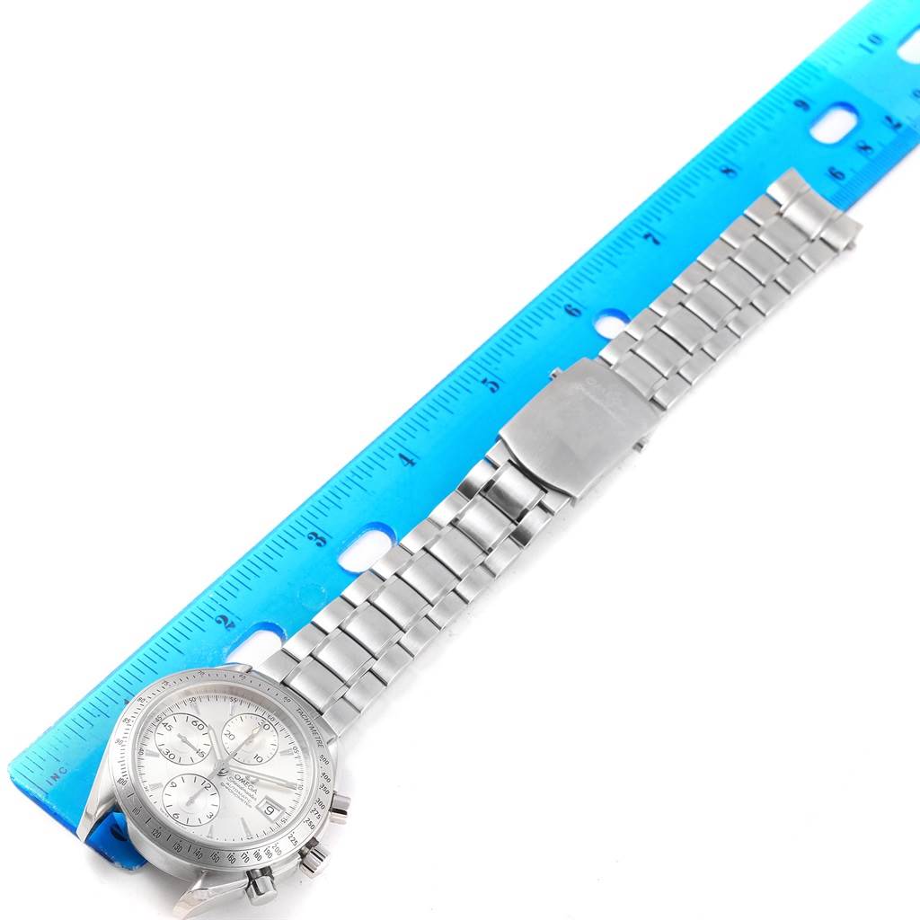 The Omega Speedmaster 3211.30.00 Men
s Stainless Steel Silver Dial 3211.30.00 Men
s Stainless Steel Silver Dial watch is shown from a top-down angle, displaying the dial, bracelet, and clasp alongside a ruler for scale.