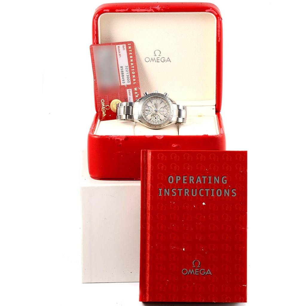 The Omega Speedmaster 3221.30.00 Men's Stainless Steel Silver Dial 3221.30.00 Men's Stainless Steel Silver Dial watch is showcased inside an open box, with the warranty card and operating instructions visible.