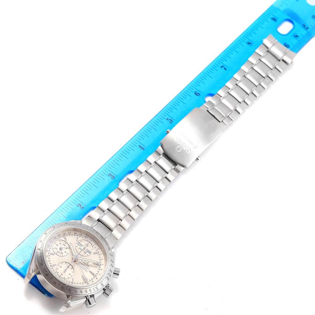 The image shows an Omega Speedmaster 3221.30.00 Men's Stainless Steel Silver Dial 3221.30.00 Men's Stainless Steel Silver Dial watch lying flat, highlighting its face, bezel, and metal bracelet with a ruler next to it for scale.