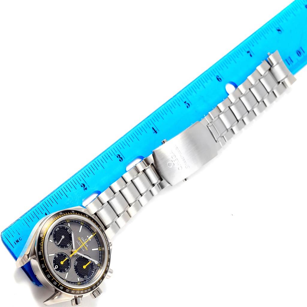 The Omega Speedmaster 326.30.40.50.06.001 Men
s Stainless Steel Grey Dial 326.30.40.50.06.001 Men
s Stainless Steel Grey Dial watch is shown from a top-down angle, displaying the face, bezel, crown, and full metal bracelet next to a blue ruler.