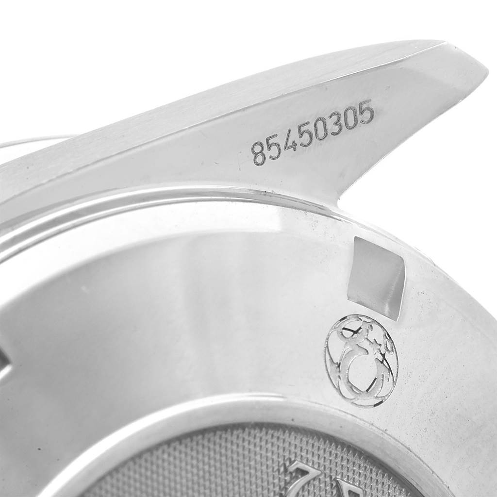 This close-up image shows the side and part of the back of an Omega Speedmaster 3210.52.00 Men
s Stainless Steel Black Dial 3210.52.00 Men
s Stainless Steel Black Dial watch, featuring an engraving and part of the Omega logo.