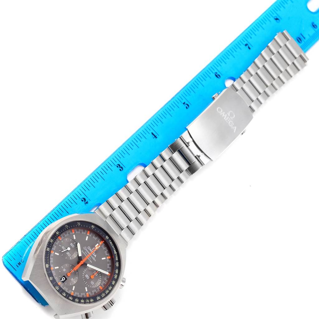 The image shows an Omega Speedmaster 327.10.43.50.06.001 Men
s Stainless Steel Grey Dial 327.10.43.50.06.001 Men
s Stainless Steel Grey Dial watch with a stainless steel bracelet and clasp, positioned next to a blue ruler.