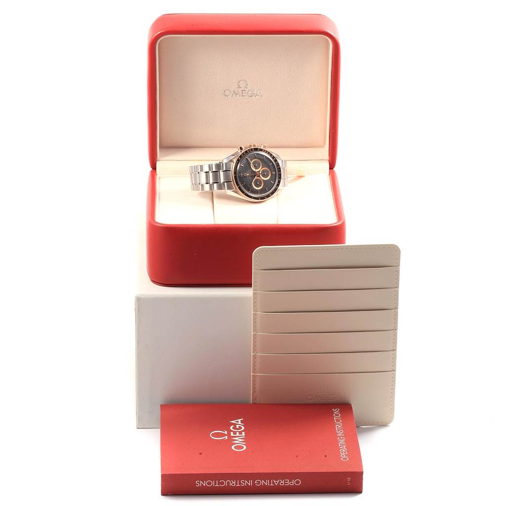 The Omega Speedmaster 3566.51.00 Men's Steel and Gold (two tone) Black Dial 3566.51.00 Men's Steel and Gold (two tone) Black Dial watch is displayed in its open box, with warranty cards and an instruction manual in front.