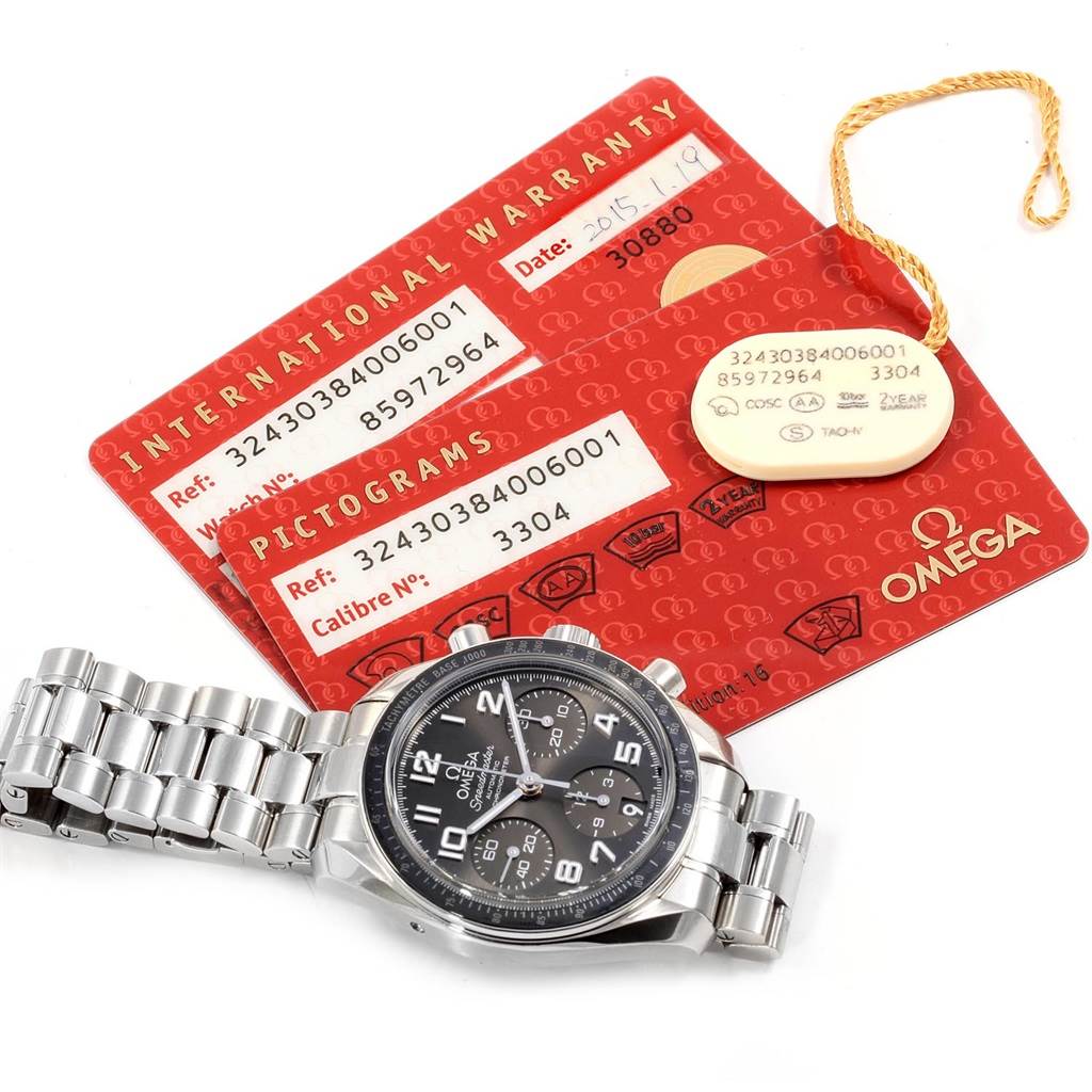 The Omega Speedmaster 324.30.38.40.06.001 Men
s Stainless Steel Grey Dial 324.30.38.40.06.001 Men
s Stainless Steel Grey Dial watch is shown in a top-down angle alongside its international warranty and pictogram cards.