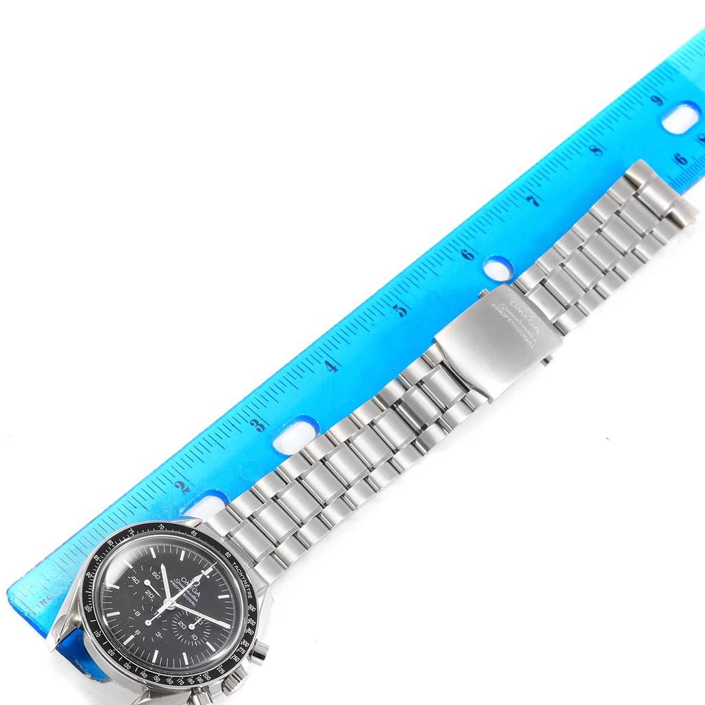 The Omega Speedmaster 3570.50.00 Men
s Stainless Steel Black Dial 3570.50.00 Men
s Stainless Steel Black Dial watch is shown in a flat position with its bracelet aligned along a blue ruler for measurement.