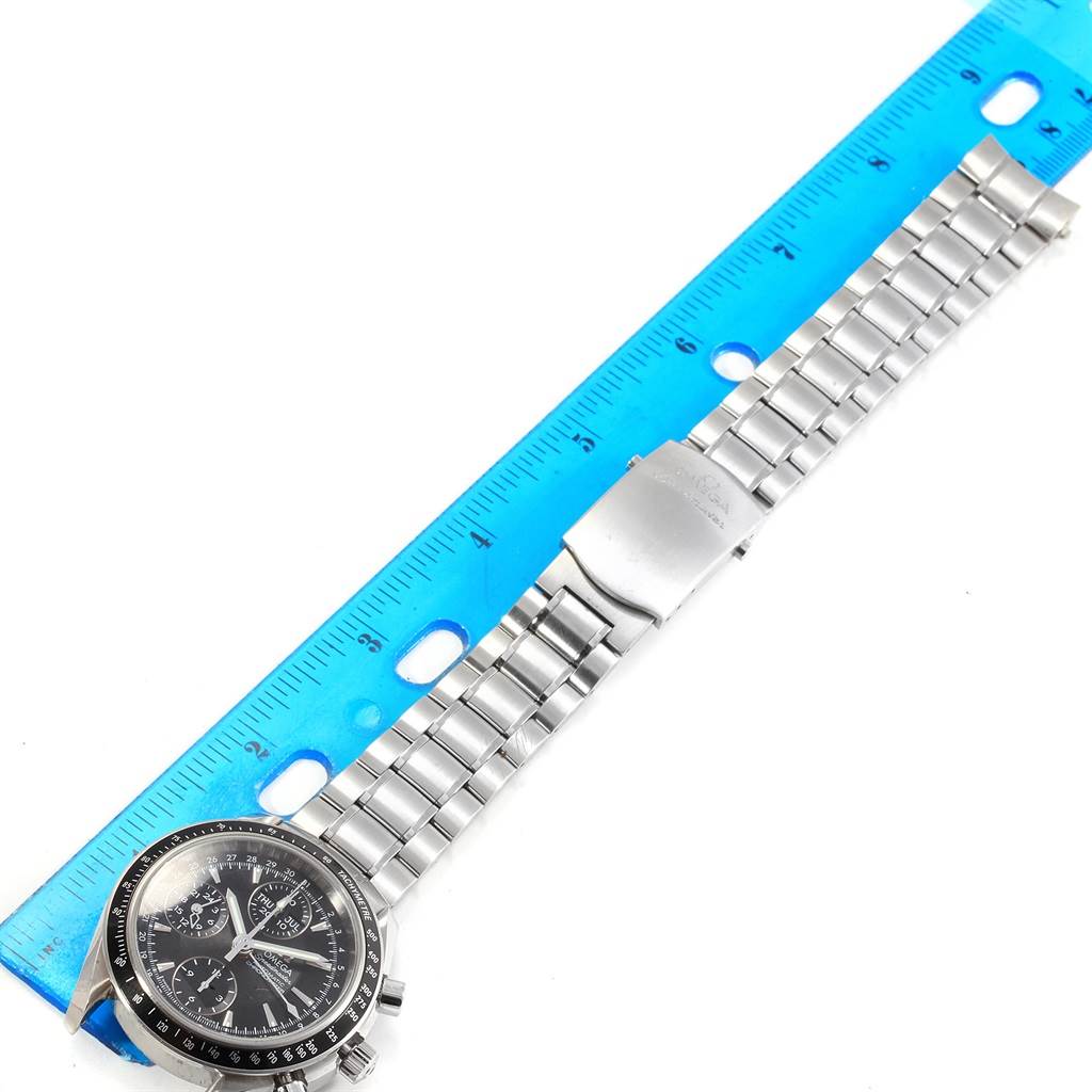 The Omega Speedmaster 3220.50.00 Men
s Stainless Steel Black Dial 3220.50.00 Men
s Stainless Steel Black Dial watch is shown from a top view next to a ruler, displaying its face and full metal bracelet.