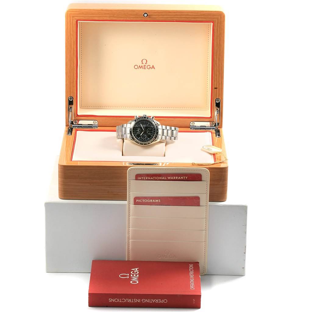 The image shows an Omega Speedmaster 3220.50.00 Men
s Stainless Steel Black Dial 3220.50.00 Men
s Stainless Steel Black Dial watch in its open box, with warranty cards and an instruction booklet in front.