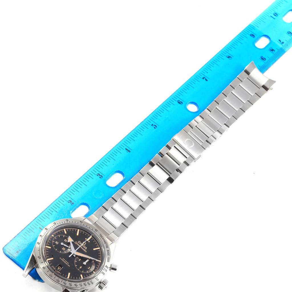 The image shows an Omega Speedmaster 331.10.42.51.01.002 Men's Stainless Steel Black Dial 331.10.42.51.01.002 Men's Stainless Steel Black Dial watch with a partially unbuckled stainless steel bracelet, placed next to a blue ruler.