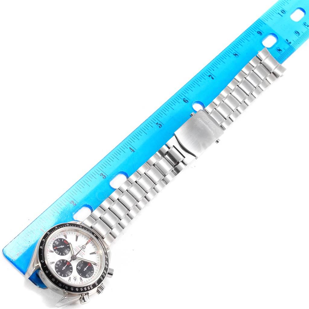 The image shows the Omega Speedmaster 323.30.40.40.04.001 Men's Stainless Steel White Dial 323.30.40.40.04.001 Men's Stainless Steel White Dial watch laid next to a ruler, highlighting the dial, bezel, and metal bracelet with clasp.