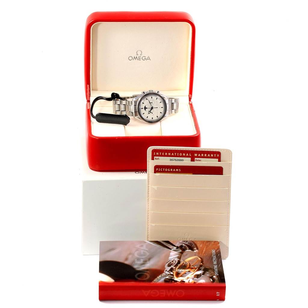 The Omega Speedmaster 3575.20.00 Men
s Stainless Steel White Dial 3575.20.00 Men
s Stainless Steel White Dial watch is displayed front-on within an open red box along with warranty cards and a booklet in front.