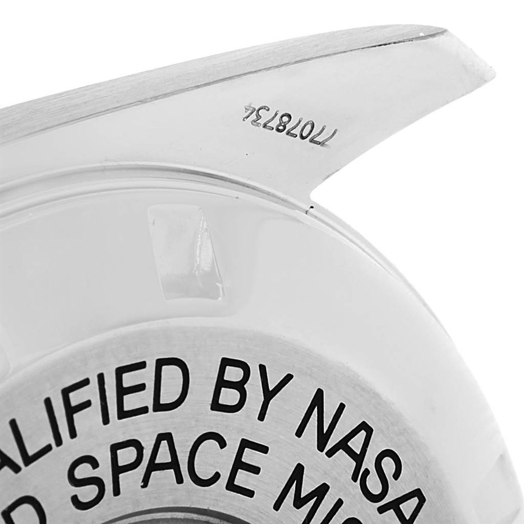 The image shows a close-up of the case back of an Omega Speedmaster 3575.20.00 Men
s Stainless Steel White Dial 3575.20.00 Men
s Stainless Steel White Dial watch, highlighting part of the text and serial number.