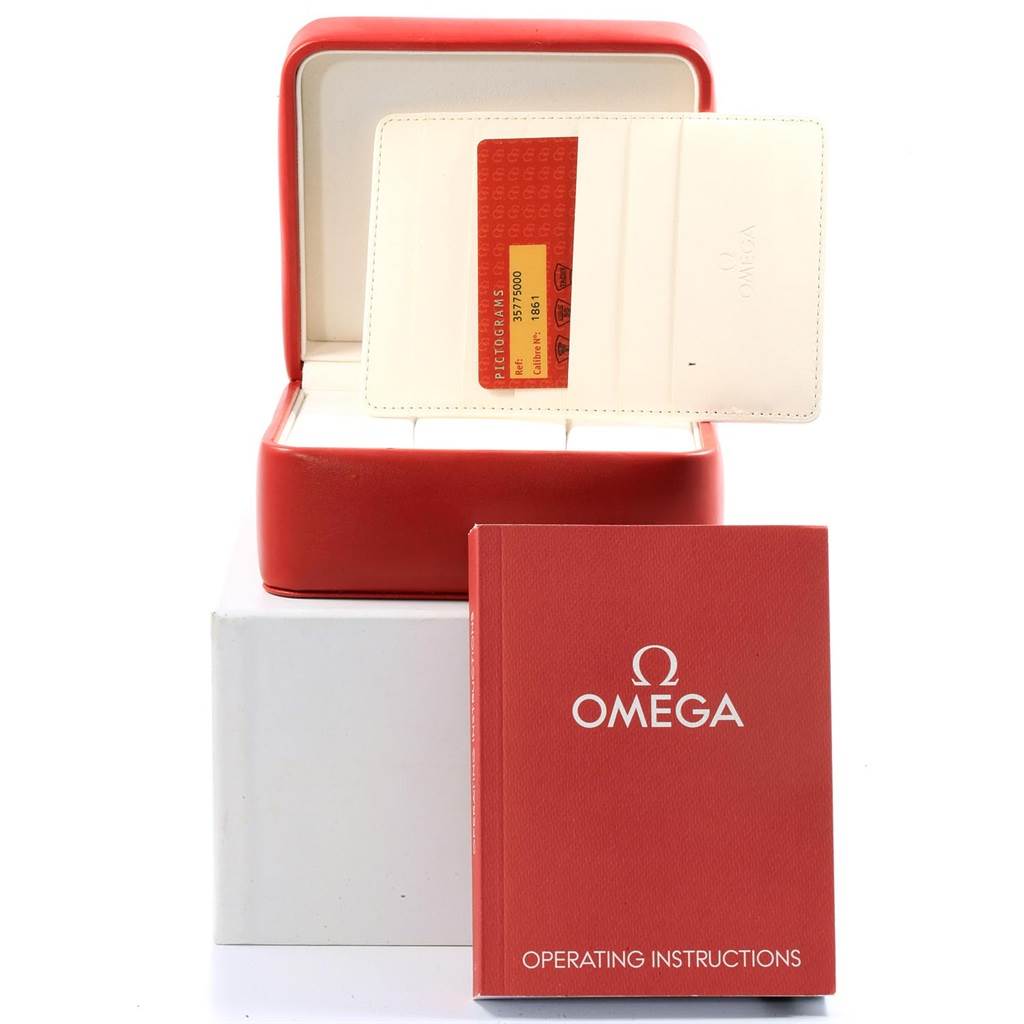 The image shows the accessories for an Omega Speedmaster 3577.50.00 Men's Stainless Steel Black Dial 3577.50.00 Men's Stainless Steel Black Dial, including a red box, warranty card, and operating instructions.