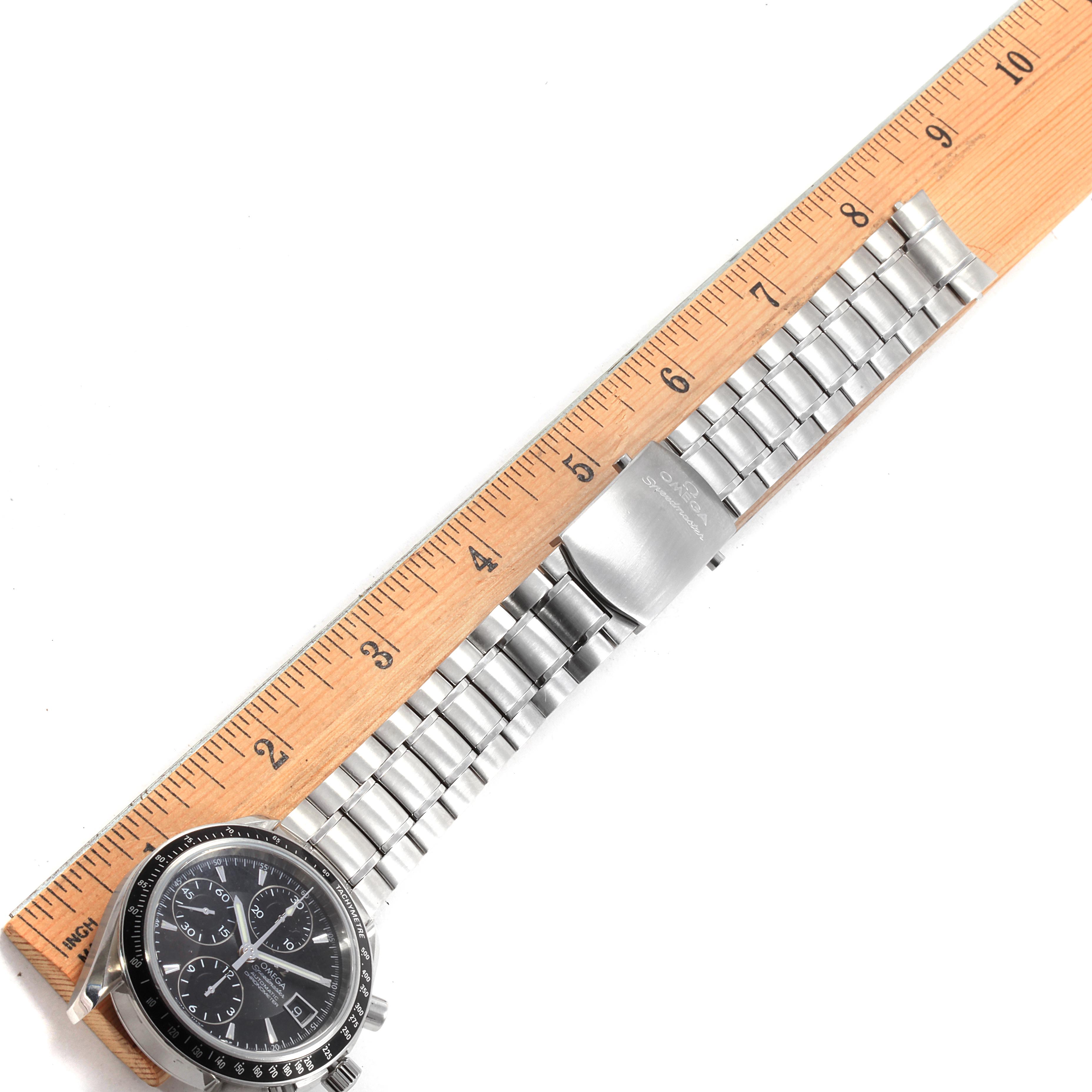 The image shows an Omega Speedmaster 3210.50.00 Men
s Stainless Steel Black Dial 3210.50.00 Men
s Stainless Steel Black Dial watch laid flat with its metal bracelet strap, next to a ruler for length reference.