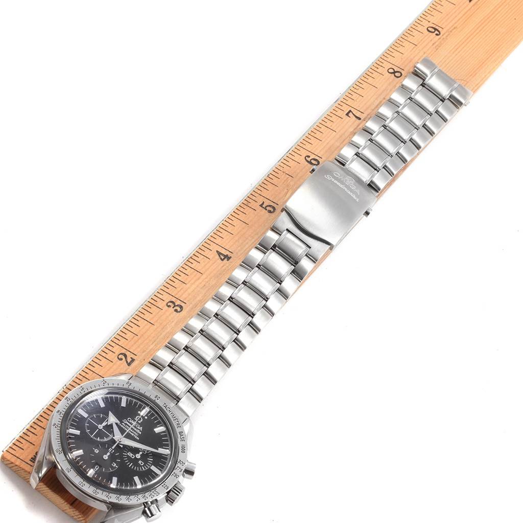 The image shows an Omega Speedmaster 3551.50.00 Men
s Stainless Steel Black Dial 3551.50.00 Men
s Stainless Steel Black Dial watch laid flat with its stainless steel bracelet extended next to a ruler for measurement.