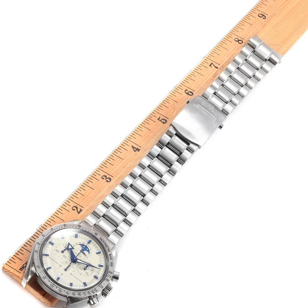 The Omega Speedmaster 3575.20.00 Men
s Stainless Steel White Dial 3575.20.00 Men
s Stainless Steel White Dial watch is shown with a metal bracelet and a clasp, next to a ruler for scale.