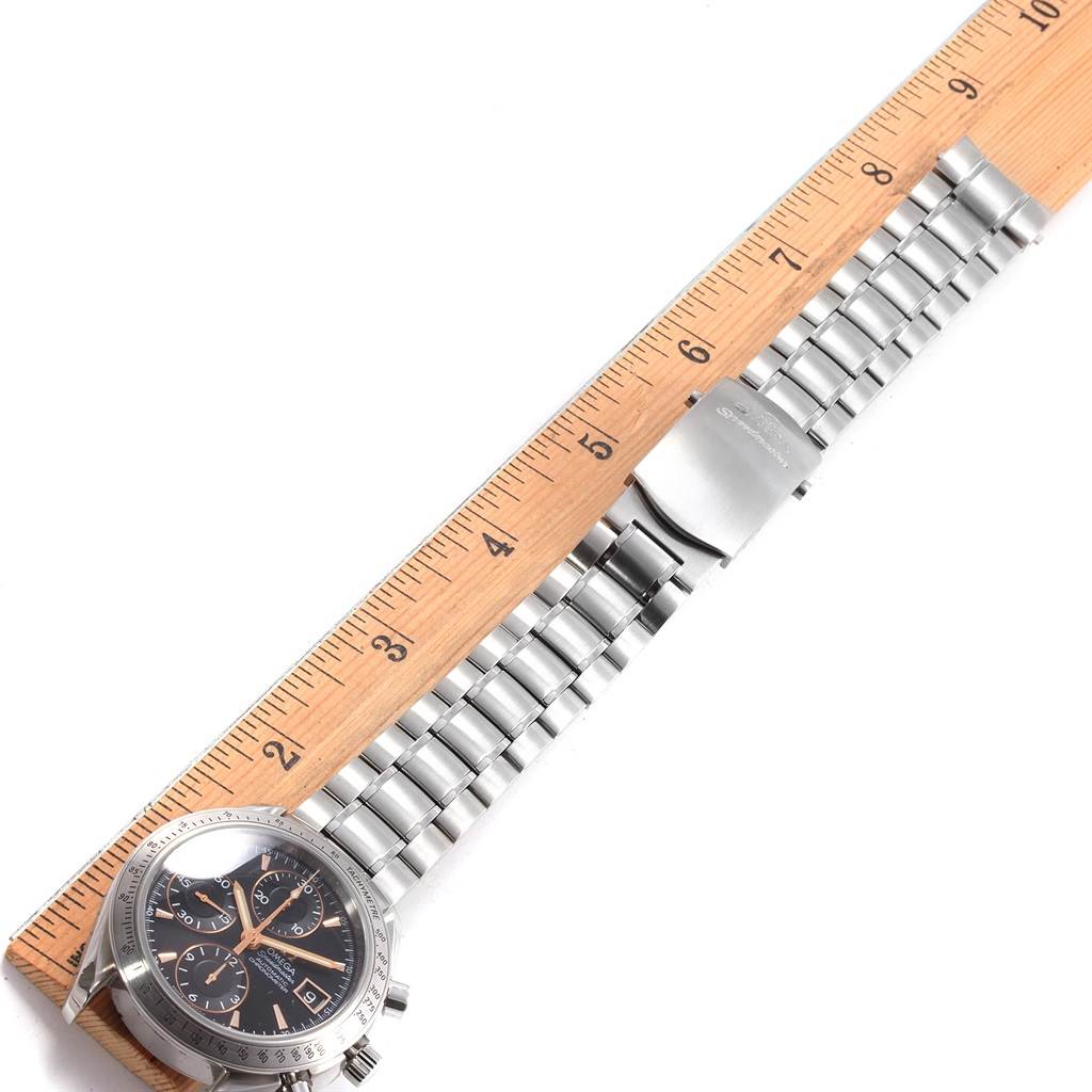 The image shows an Omega Speedmaster 3211.50.00 Men
s Stainless Steel Black Dial 3211.50.00 Men
s Stainless Steel Black Dial watch laid flat with a ruler measuring its metal bracelet and clasp.