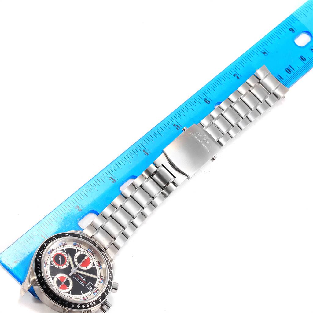 The image shows an Omega Speedmaster 3210.52.00 Men
s Stainless Steel Black Dial 3210.52.00 Men
s Stainless Steel Black Dial watch laid flat with a stainless steel bracelet next to a blue measuring ruler.