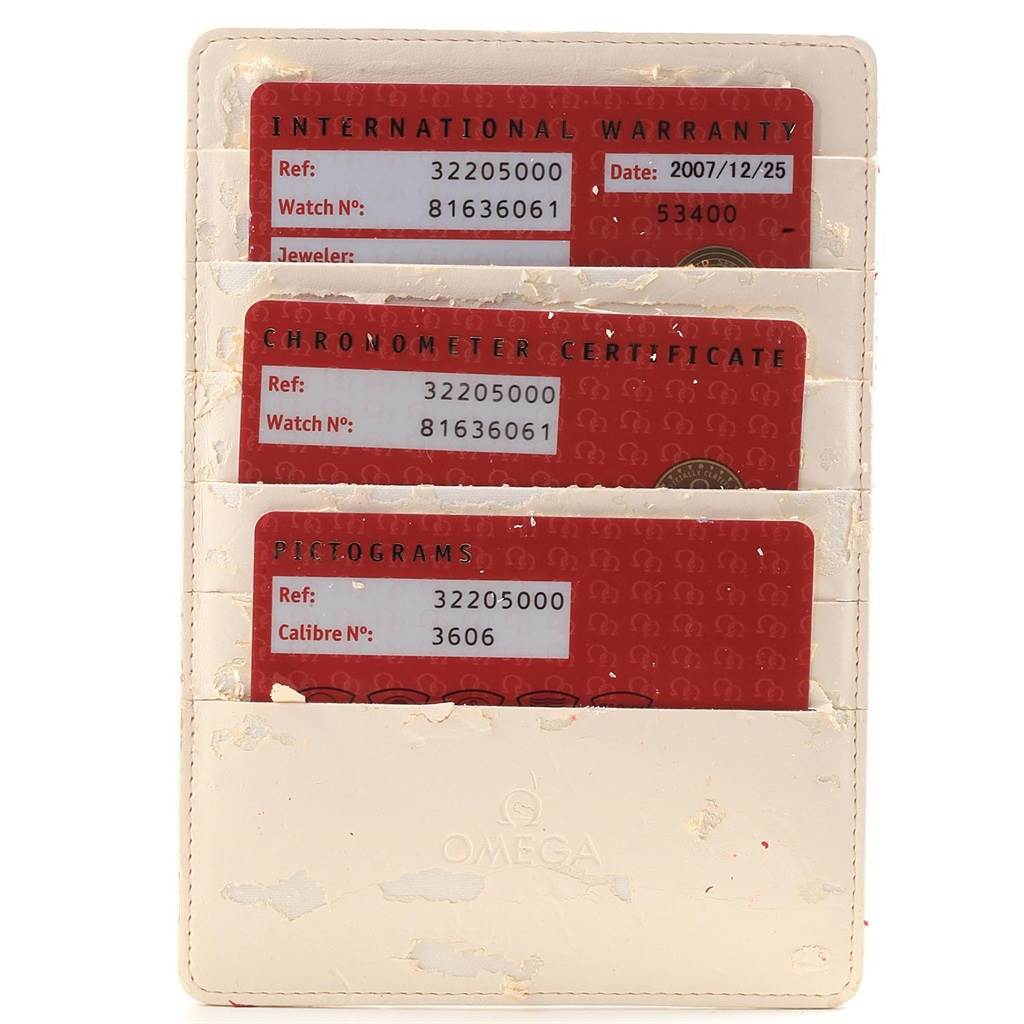 The image shows an Omega Speedmaster 3220.50.00 Men
s Stainless Steel Black Dial 3220.50.00 Men
s Stainless Steel Black Dial
s International Warranty, Chronometer Certificate, and Pictogram cards in a holder.