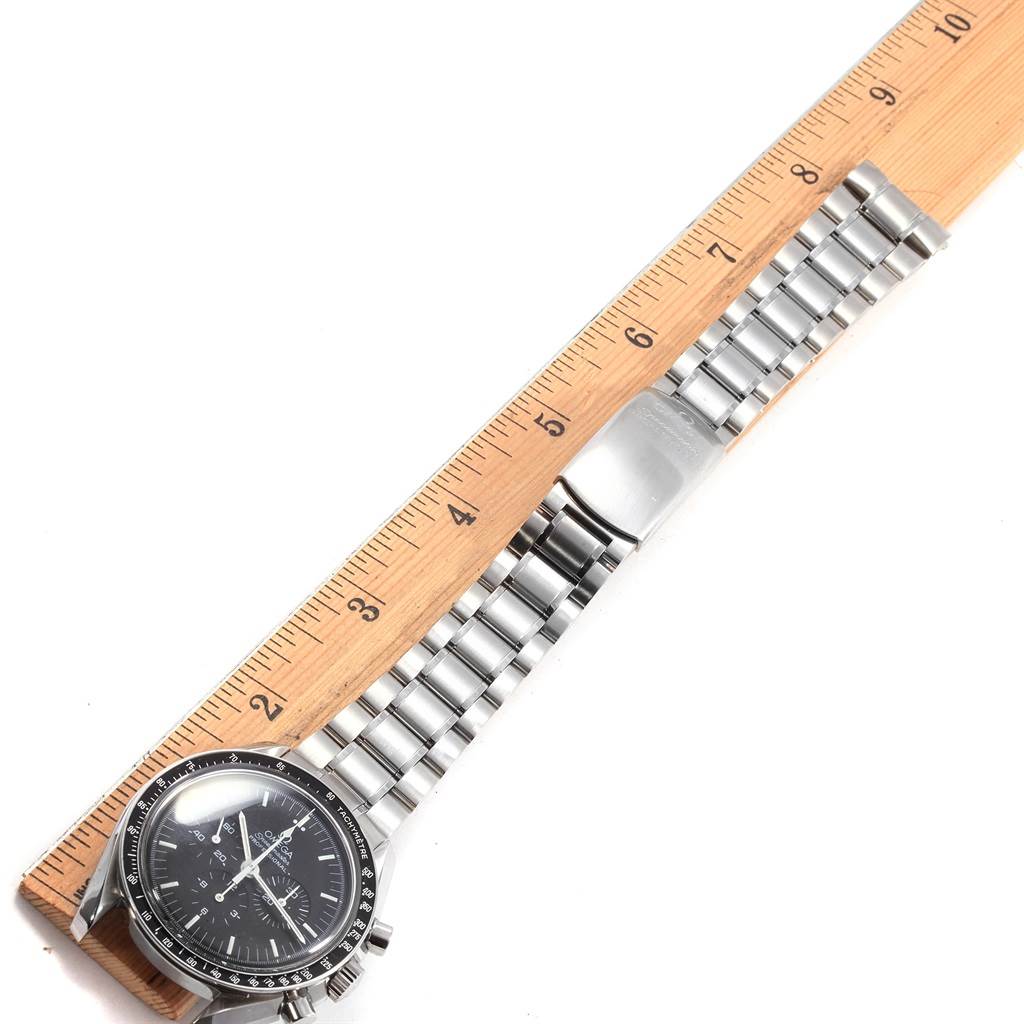The Omega Speedmaster 3560.50.00 Men
s Stainless Steel Black Dial 3560.50.00 Men
s Stainless Steel Black Dial watch is shown flat, next to a ruler with its face and full metal bracelet band visible.
