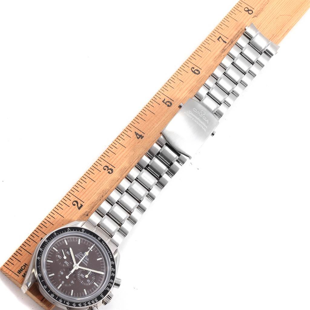 The image shows the Omega Speedmaster 311.30.42.30.13.001 Men's Stainless Steel Brown Dial 311.30.42.30.13.001 Men's Stainless Steel Brown Dial watch laid flat, with the watch face, stainless steel bracelet, and clasp placed alongside a ruler.