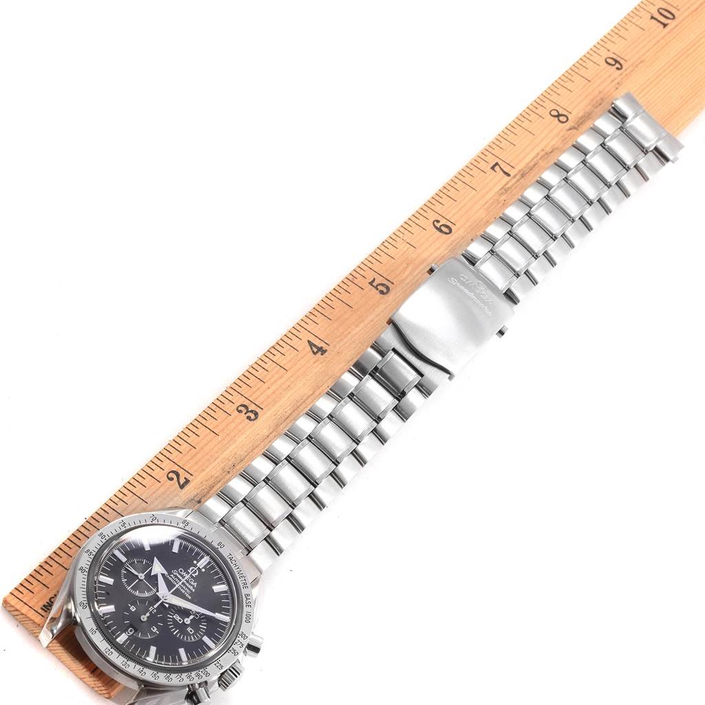 The image shows an Omega Speedmaster 3551.50.00 Men
s Stainless Steel Black Dial 3551.50.00 Men
s Stainless Steel Black Dial watch laid flat, with its metal bracelet fully extended next to a ruler for size reference.
