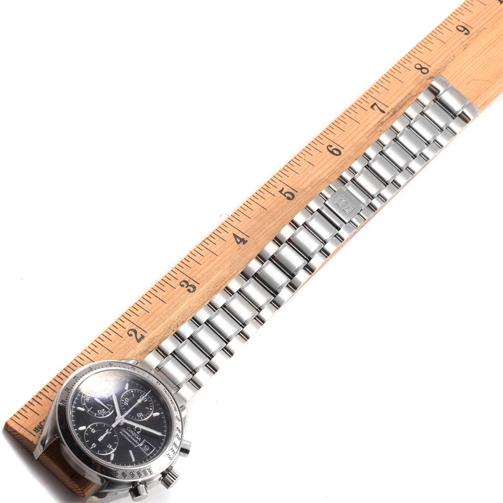 The image shows an Omega Speedmaster 3513.50.00 Men
s Stainless Steel Black Dial 3513.50.00 Men
s Stainless Steel Black Dial watch lying flat with a ruler measuring its stainless steel bracelet.