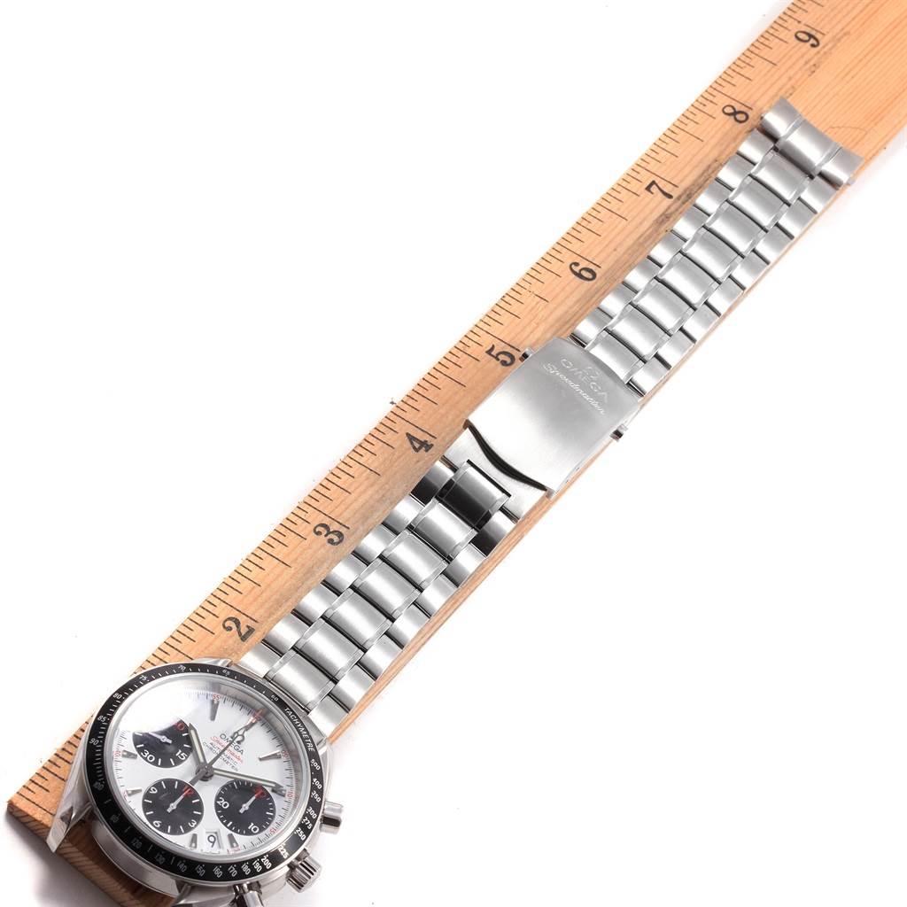 The Omega Speedmaster 323.30.40.40.04.001 Men's Stainless Steel White Dial 323.30.40.40.04.001 Men's Stainless Steel White Dial watch is shown from above, highlighting its face, stainless steel bracelet, and clasp next to a ruler.