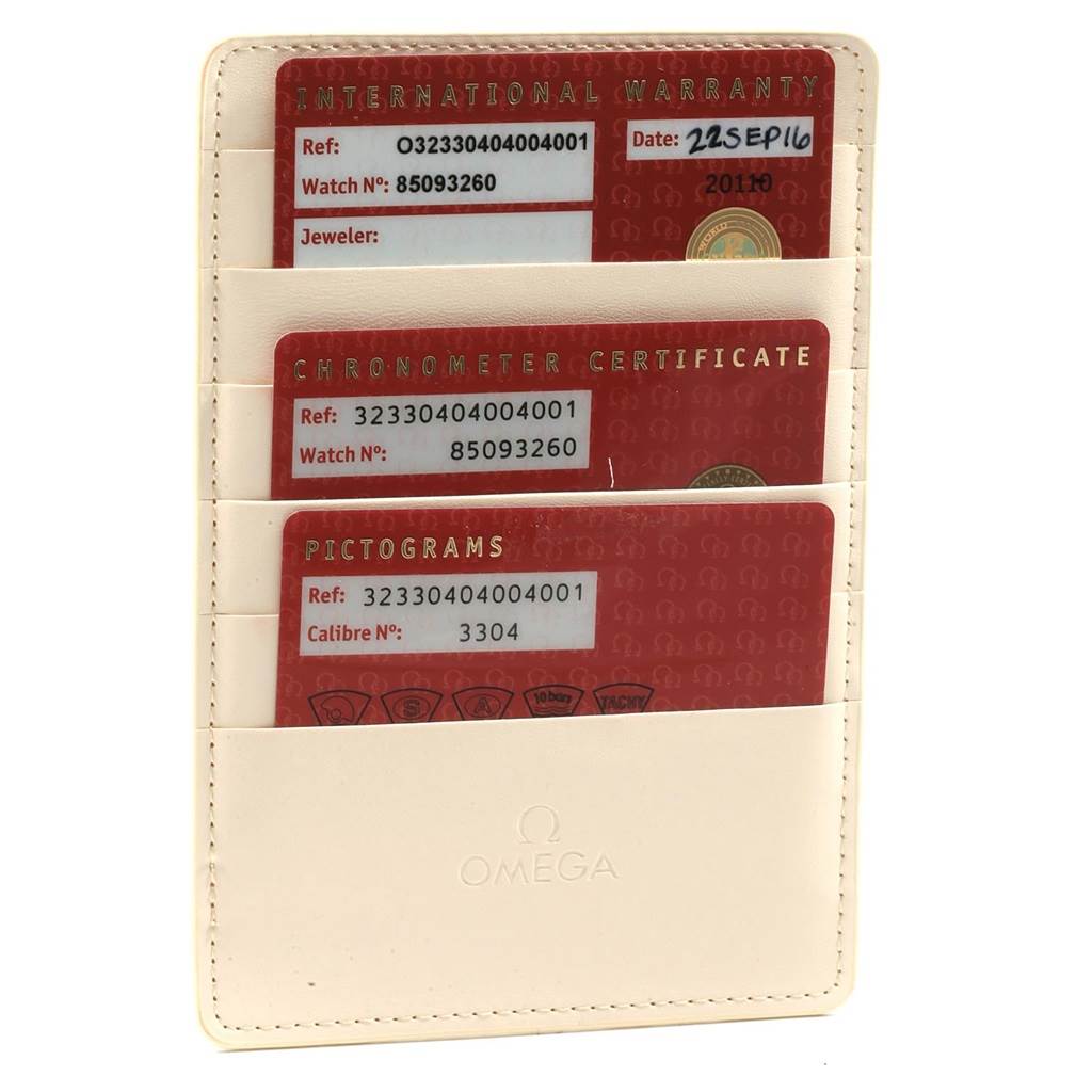 The image shows three warranty and certificate cards for the Omega Speedmaster 323.30.40.40.04.001 Men's Stainless Steel White Dial 323.30.40.40.04.001 Men's Stainless Steel White Dial, held in a beige Omega cardholder.