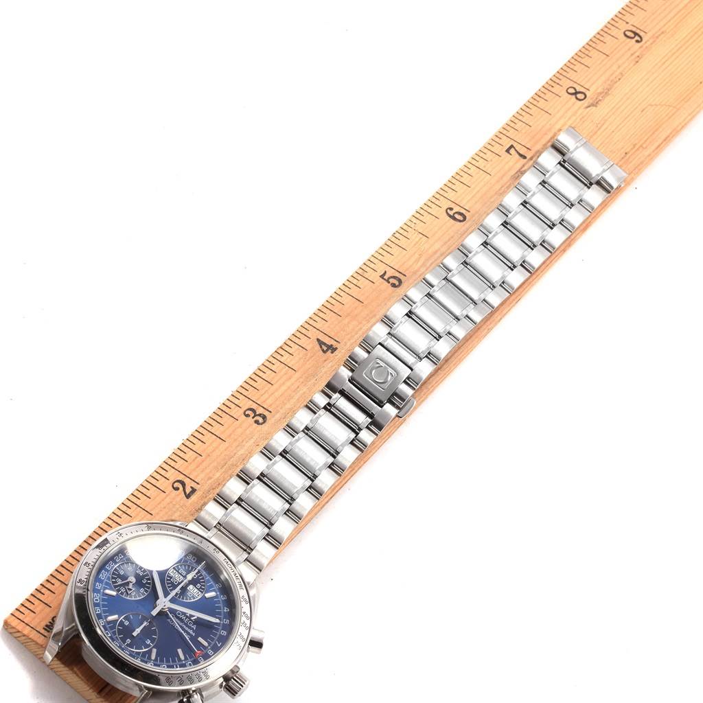 This image shows an Omega Speedmaster 3523.80.00 Men
s Stainless Steel Blue Dial 3523.80.00 Men
s Stainless Steel Blue Dial watch from an overhead angle, alongside a wooden ruler for scale.