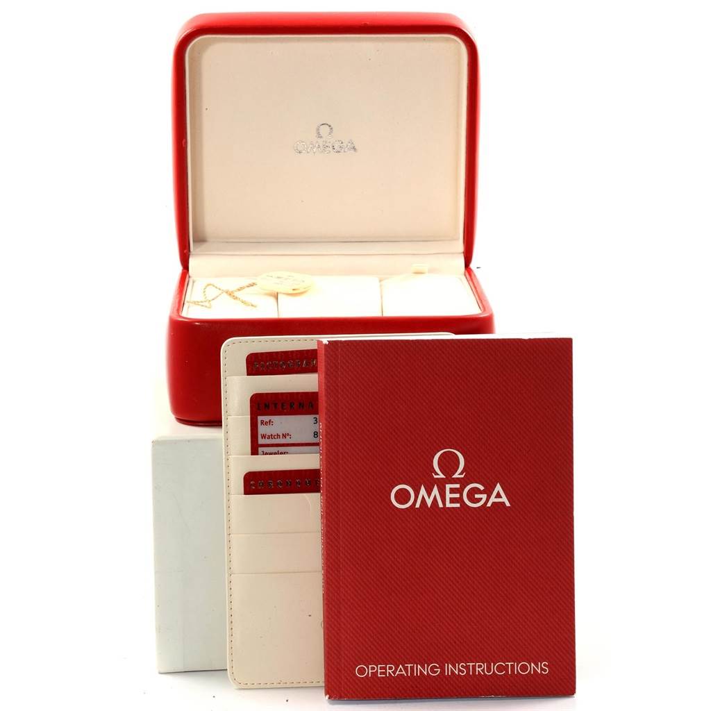 The image shows an open red Omega Speedmaster 3211.30.00 Men
s Stainless Steel Silver Dial 3211.30.00 Men
s Stainless Steel Silver Dial watch box, operating instructions, and a warranty card holder.