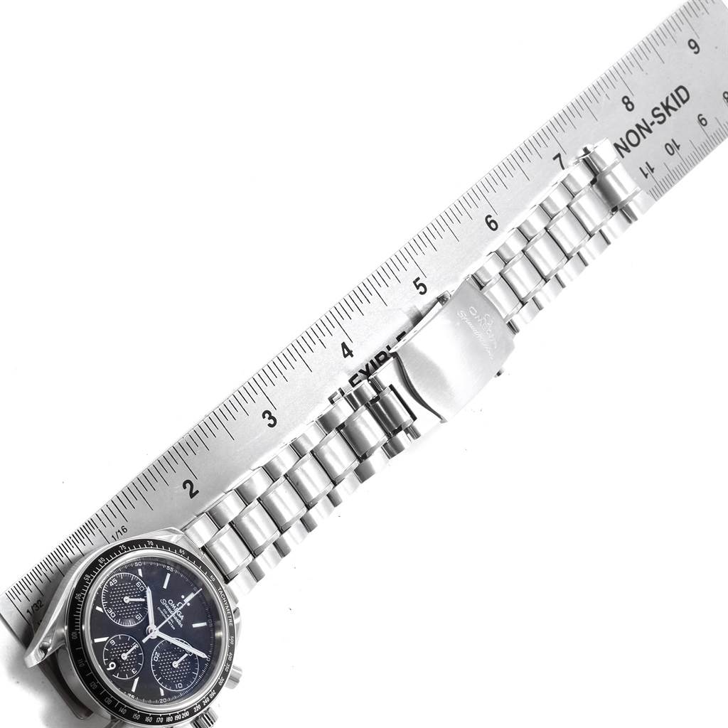 The Omega Speedmaster 326.30.40.50.01.001 Men
s Stainless Steel Black Dial 326.30.40.50.01.001 Men
s Stainless Steel Black Dial watch is shown laying flat with its face, bracelet, and clasp visible alongside a ruler for measurement.