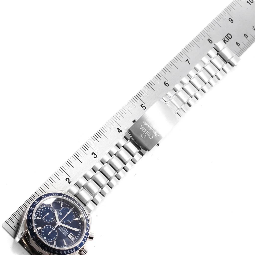 The image shows an Omega Speedmaster 3212.80.00 Men
s Stainless Steel Blue Dial 3212.80.00 Men
s Stainless Steel Blue Dial watch, angled to display the dial, stainless steel bracelet, and clasp, with a ruler for measurement.