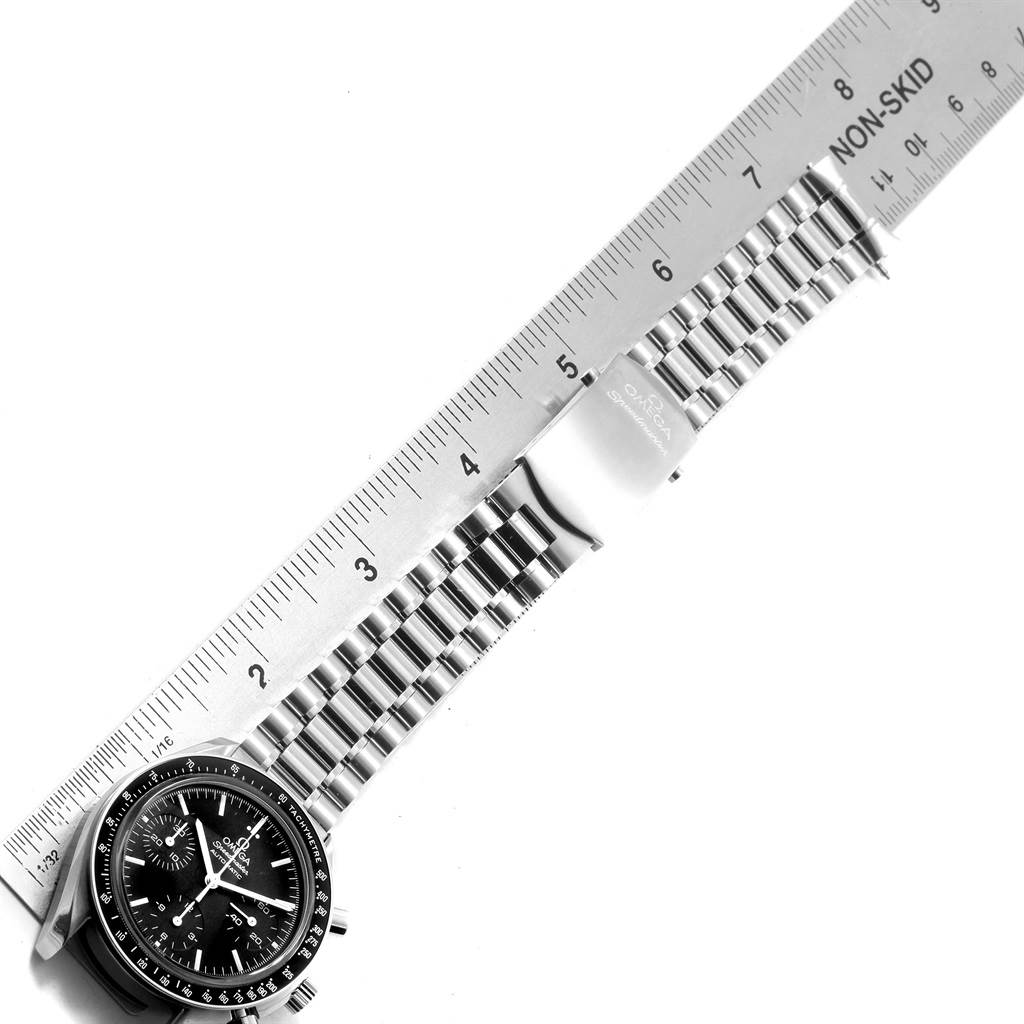 The image shows an Omega Speedmaster 3539.50.00 Men
s Stainless Steel Black Dial 3539.50.00 Men
s Stainless Steel Black Dial watch laid flat, with a ruler measuring its stainless steel bracelet and clasp.