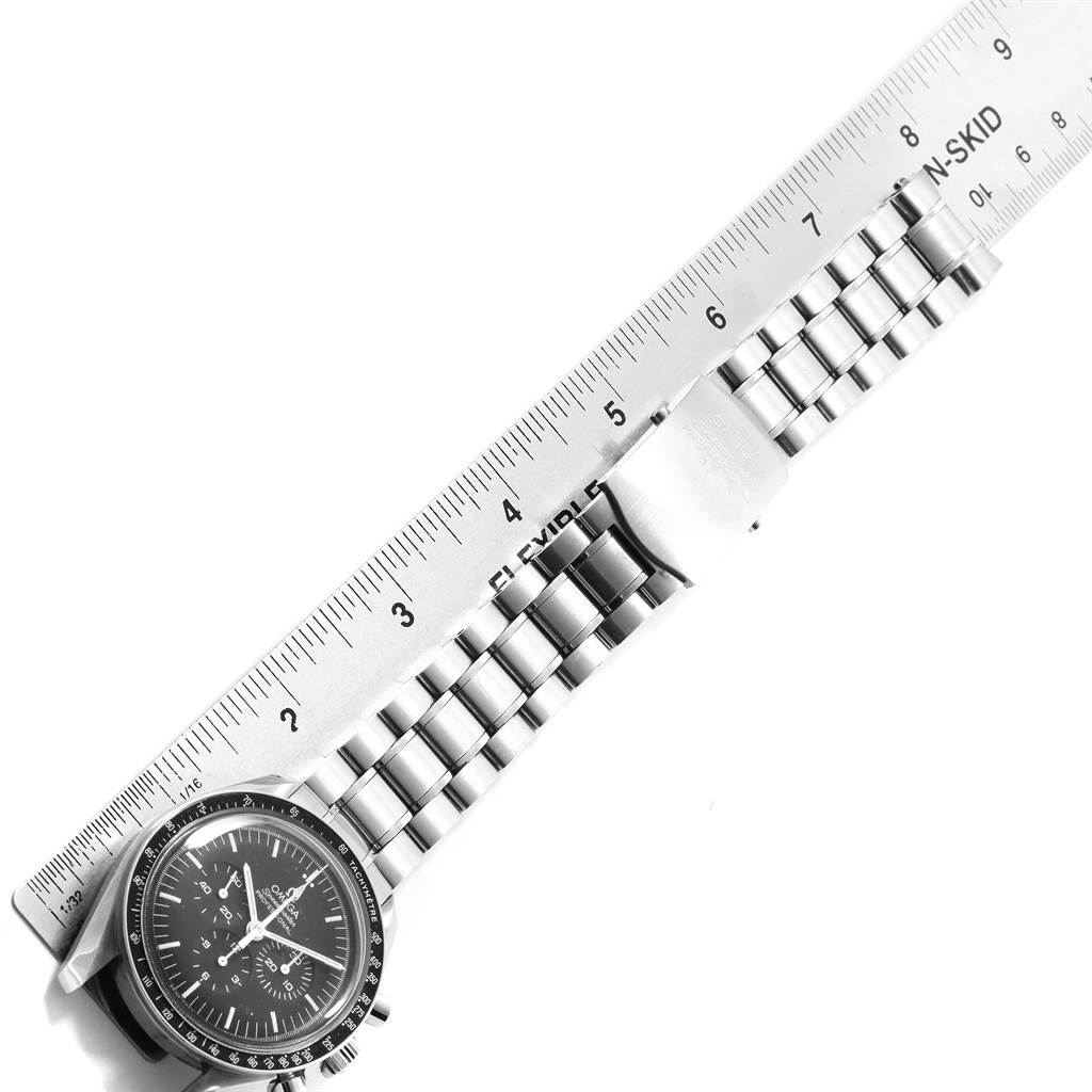 The image shows an Omega Speedmaster 311.30.42.30.01.005 Men
s Stainless Steel Black Dial 311.30.42.30.01.005 Men
s Stainless Steel Black Dial watch from a top view with its dial, bracelet, and clasp placed against a ruler.