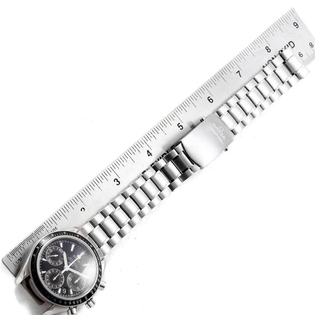 The image shows an Omega Speedmaster 323.30.40.40.01.001 Men
s Stainless Steel Black Dial 323.30.40.40.01.001 Men
s Stainless Steel Black Dial watch laid flat with an extended metal bracelet and a ruler placed alongside for scale reference.