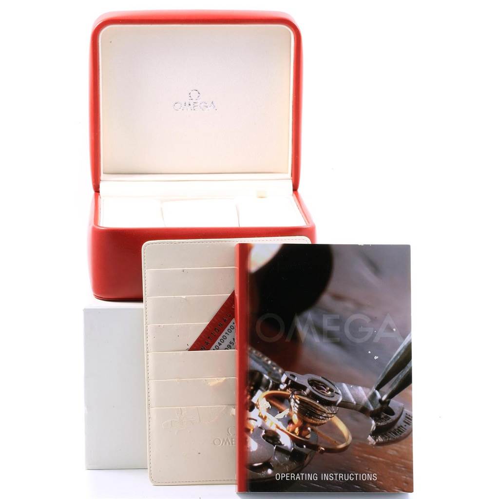 The image shows an Omega Speedmaster 323.30.40.40.01.001 Men
s Stainless Steel Black Dial 323.30.40.40.01.001 Men
s Stainless Steel Black Dial watch box, operating instructions booklet, and a leather cardholder with cards.