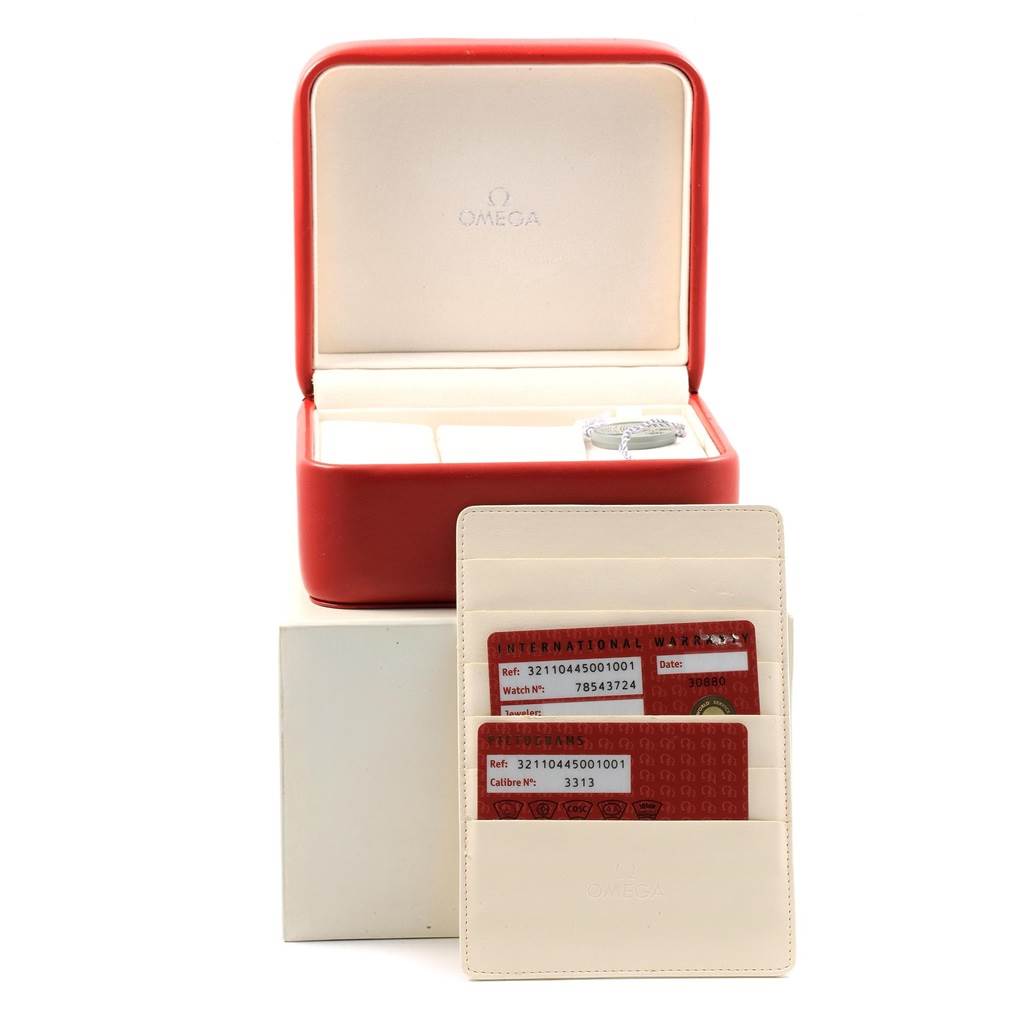 The image shows a red Omega Speedmaster 321.10.44.50.01.001 Men
s Stainless Steel Black Dial 321.10.44.50.01.001 Men
s Stainless Steel Black Dial watch box with warranty cards and instruction manual.
