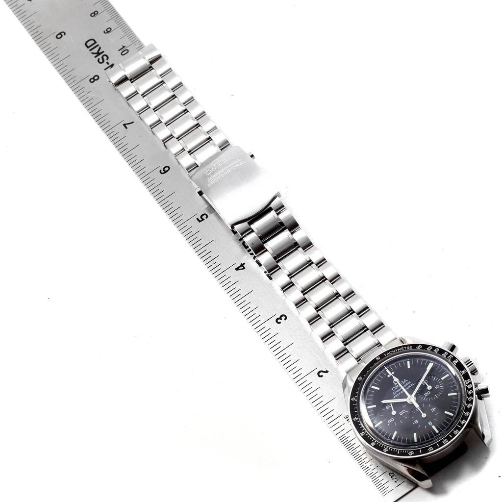 The image shows the front view of an Omega Speedmaster 3570.50.00 Men
s Stainless Steel Black Dial 3570.50.00 Men
s Stainless Steel Black Dial watch with its stainless steel bracelet and clasp alongside a ruler.