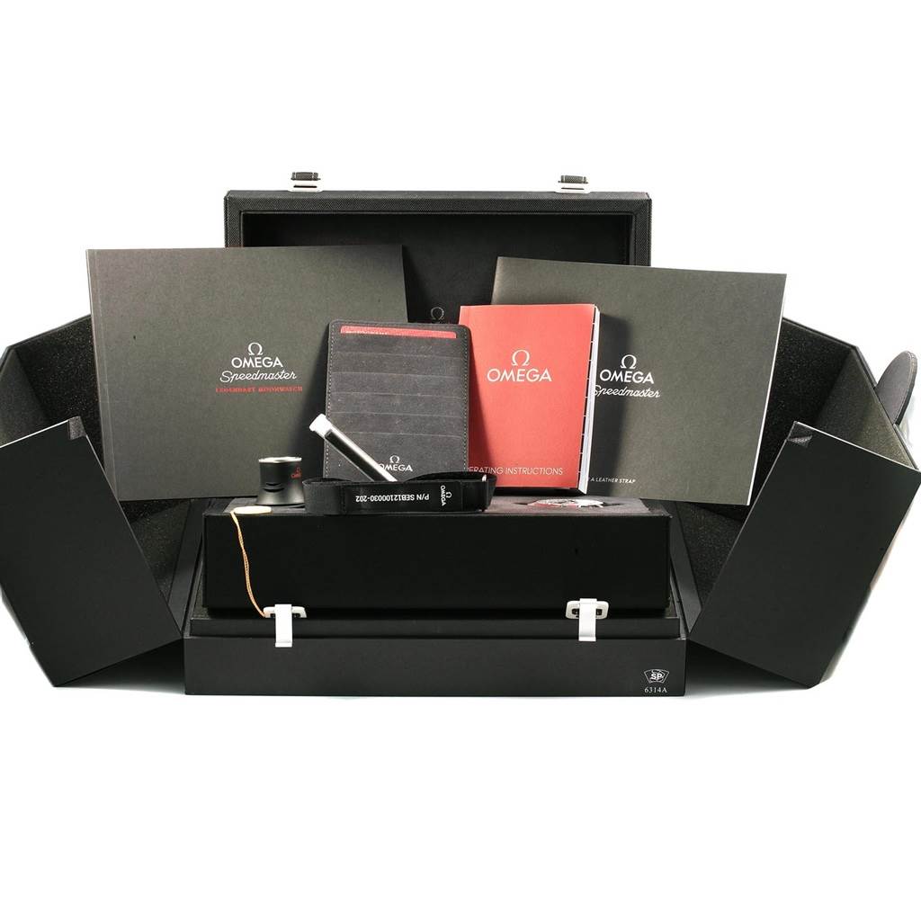 The image shows the box and accessories for the Omega Speedmaster 311.33.42.30.01.001 Men
s Stainless Steel Black Dial 311.33.42.30.01.001 Men
s Stainless Steel Black Dial, including manuals, a loupe, and a NATO strap.