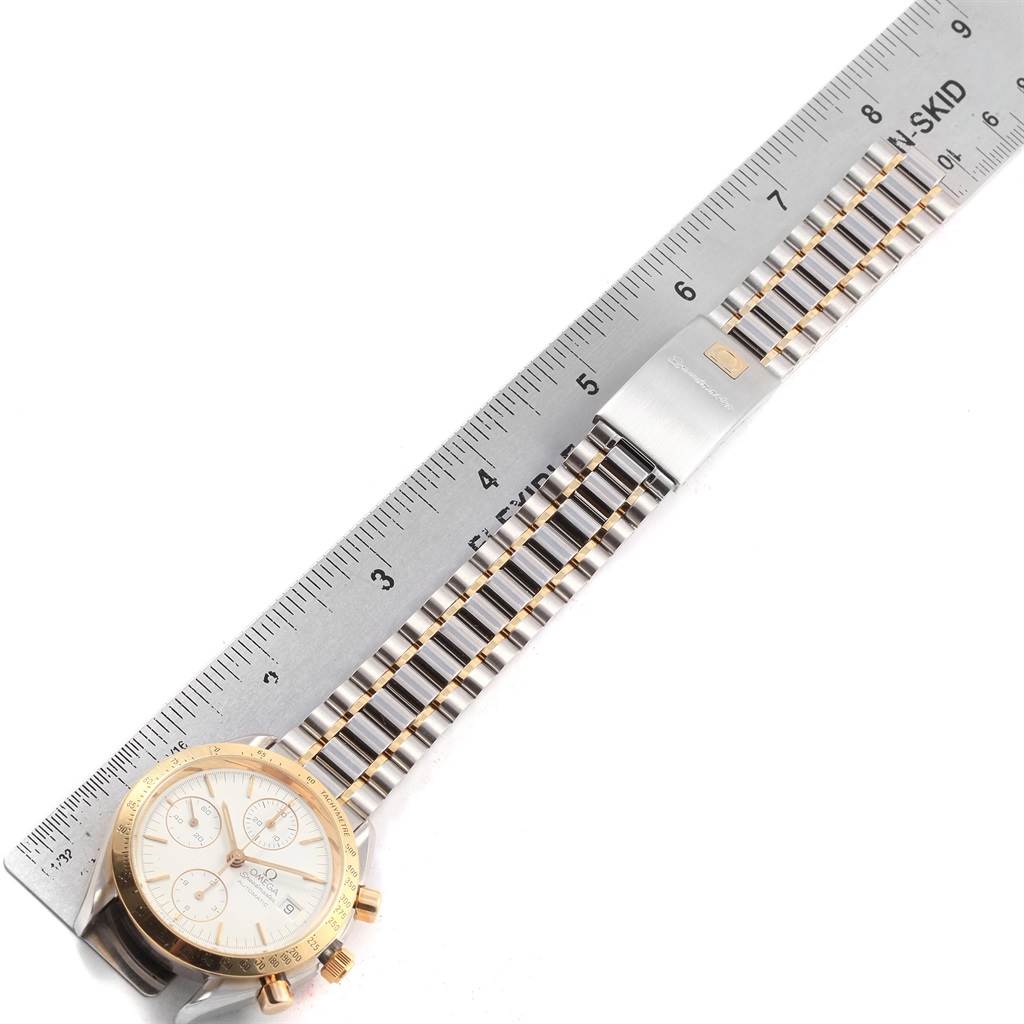 The image shows an Omega Speedmaster 3311.20.00 Men's Steel and Gold (two tone) White Dial 3311.20.00 Men's Steel and Gold (two tone) White Dial watch, including its face and metal bracelet, measured with a ruler.